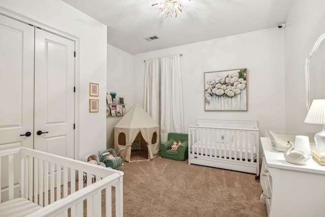 bedroom with a nursery area, light colored carpet, and a closet