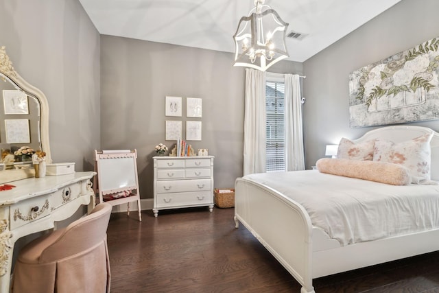 bedroom featuring dark hardwood / wood-style flooring and an inviting chandelier