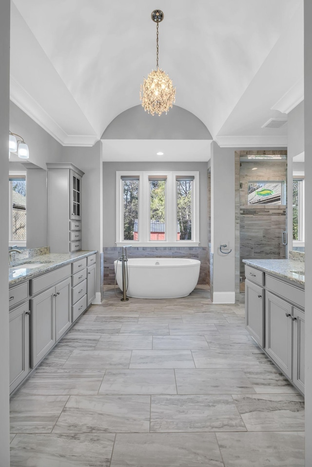 bathroom with independent shower and bath, vaulted ceiling, a notable chandelier, and vanity