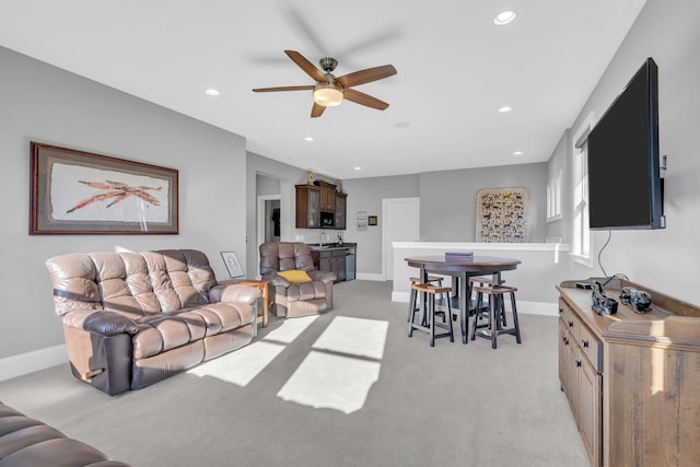 carpeted living room featuring sink and ceiling fan