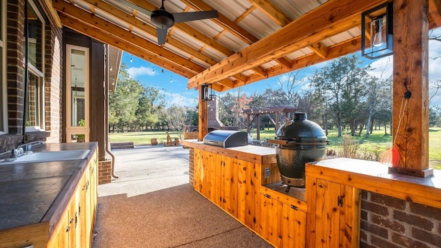 view of patio featuring exterior kitchen, ceiling fan, sink, and grilling area