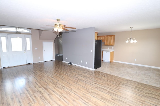 unfurnished living room featuring ceiling fan with notable chandelier and light hardwood / wood-style floors