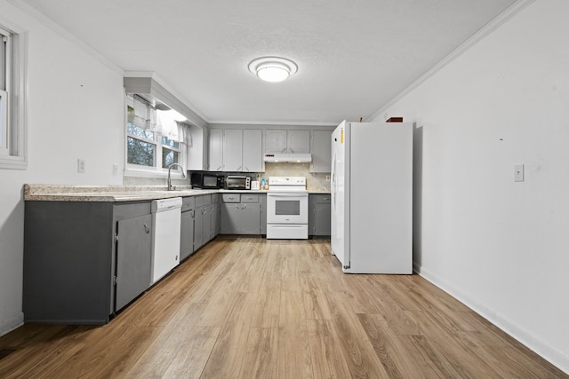 kitchen with white appliances, light hardwood / wood-style flooring, crown molding, gray cabinetry, and tasteful backsplash