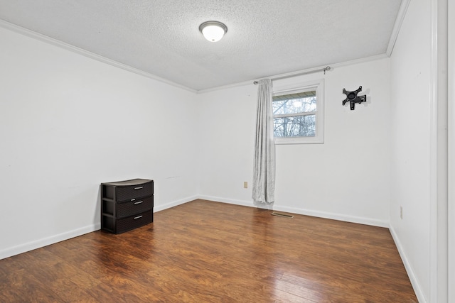 spare room with ornamental molding, dark hardwood / wood-style flooring, and a textured ceiling