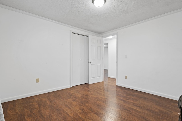 unfurnished room with crown molding, dark wood-type flooring, and a textured ceiling