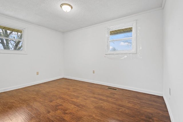 unfurnished room with a healthy amount of sunlight, dark wood-type flooring, and ornamental molding