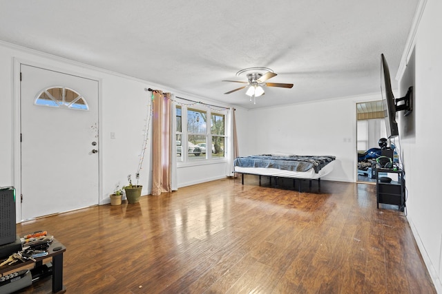 entrance foyer featuring ceiling fan, wood-type flooring, ornamental molding, and a textured ceiling