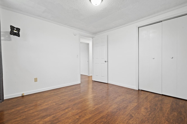 unfurnished bedroom with dark wood-type flooring, ornamental molding, a closet, and a textured ceiling