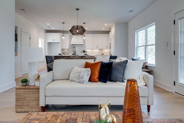 living room featuring sink and light wood-type flooring