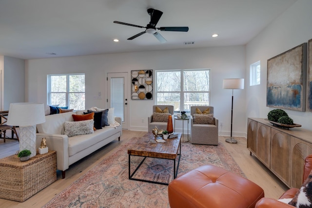 living room with plenty of natural light, ceiling fan, and light hardwood / wood-style flooring