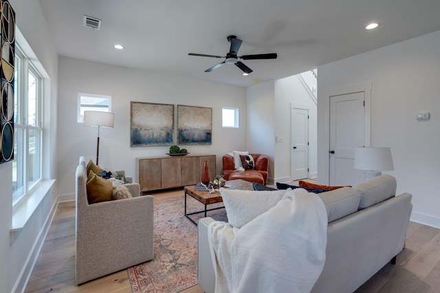 living room featuring ceiling fan, plenty of natural light, and light wood-type flooring