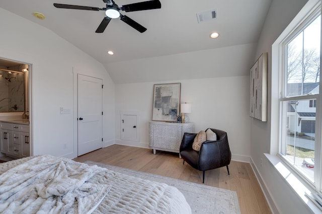 bedroom with sink, ceiling fan, connected bathroom, light hardwood / wood-style floors, and vaulted ceiling