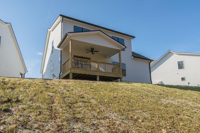 rear view of house featuring a lawn, ceiling fan, and a deck