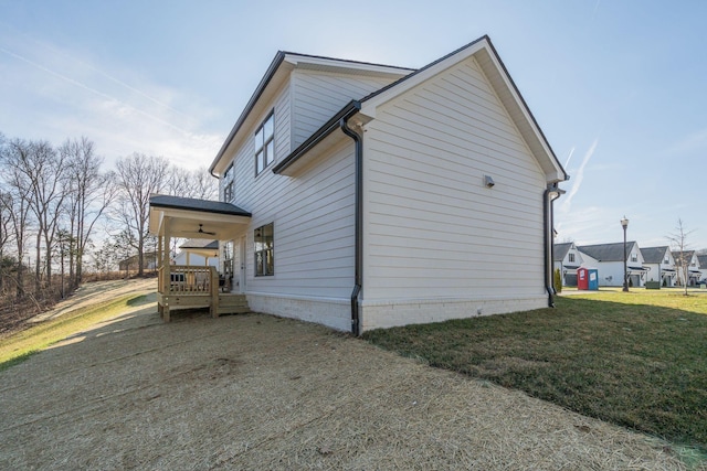 view of side of home with a porch and a yard