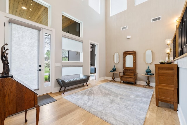 entrance foyer with a towering ceiling and light hardwood / wood-style floors