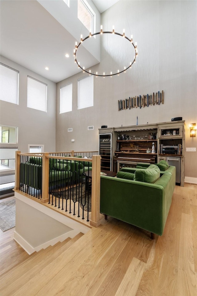 interior space with a towering ceiling, wood-type flooring, and a chandelier