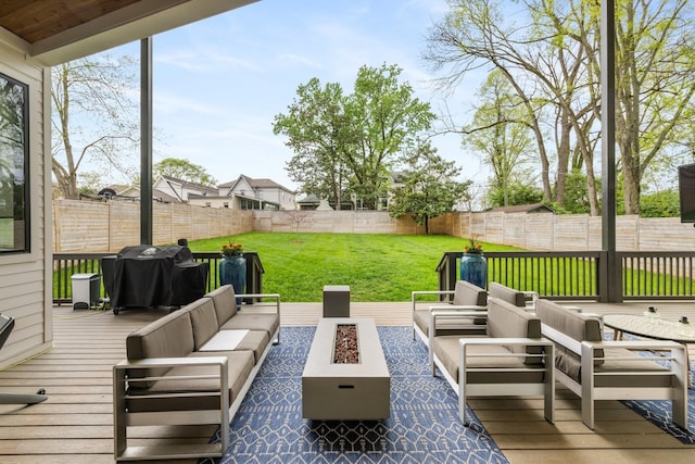 wooden terrace with a grill, a lawn, and an outdoor living space with a fire pit