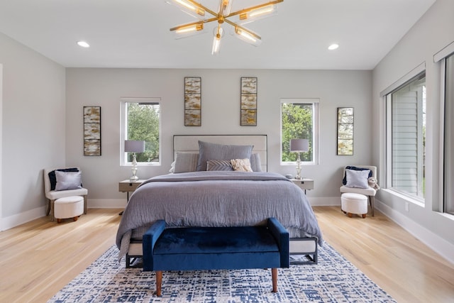 bedroom with a notable chandelier and light hardwood / wood-style floors