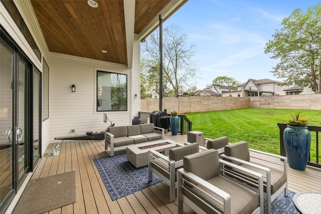 wooden terrace with a yard and an outdoor living space with a fire pit