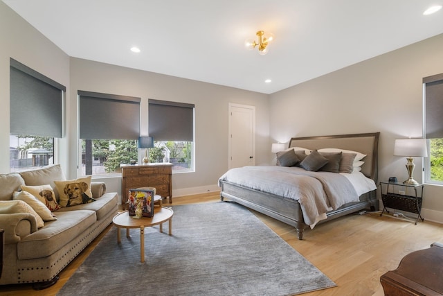 bedroom with light hardwood / wood-style floors and multiple windows