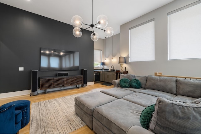 living room featuring a notable chandelier and light wood-type flooring