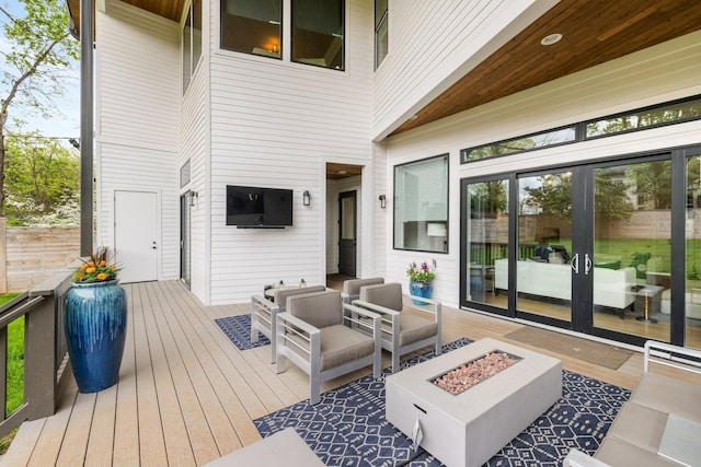 wooden deck featuring an outdoor living space with a fire pit