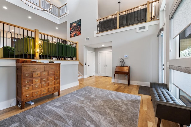 entrance foyer with a towering ceiling and wood-type flooring