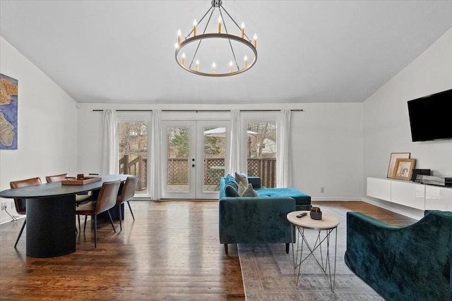 living room with dark hardwood / wood-style floors, vaulted ceiling, french doors, and a chandelier