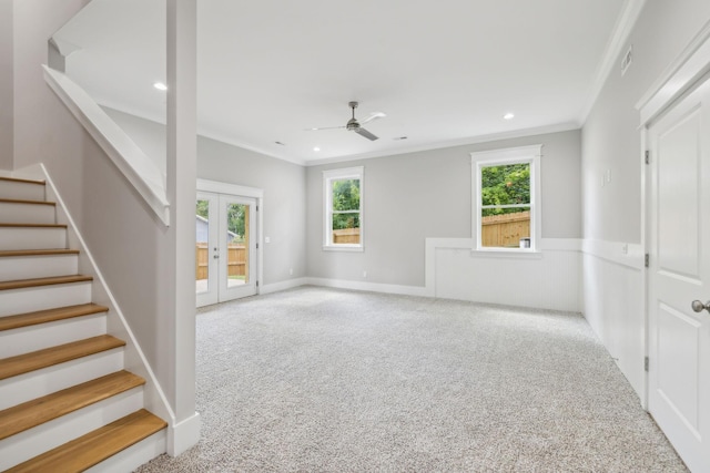 interior space featuring ornamental molding, light colored carpet, ceiling fan, and french doors