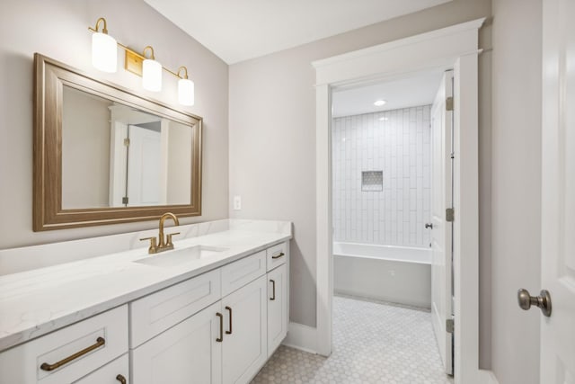 bathroom featuring tiled shower / bath and vanity