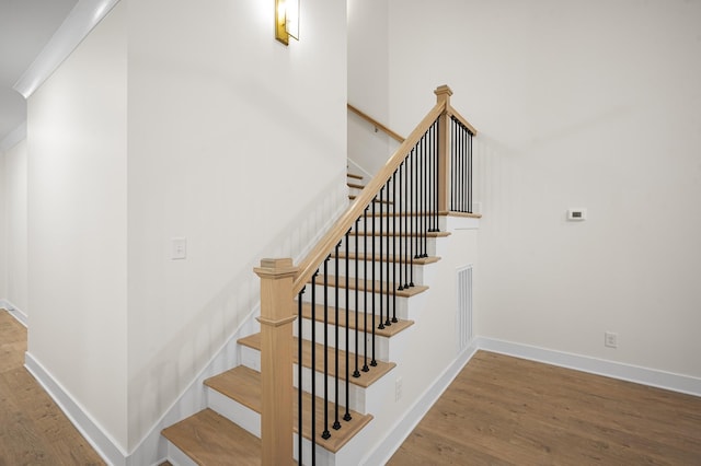 staircase with hardwood / wood-style floors