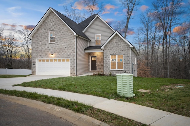 view of property with a garage and a lawn