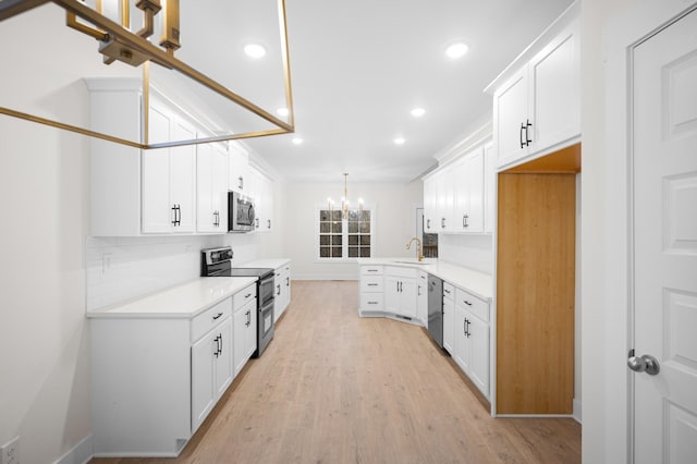 kitchen featuring sink, light hardwood / wood-style flooring, stainless steel appliances, white cabinets, and decorative light fixtures