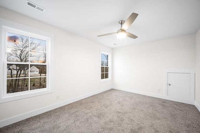 carpeted spare room with ceiling fan