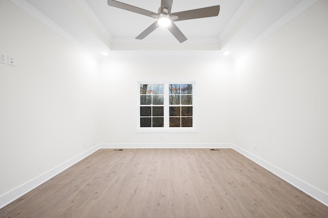 unfurnished room featuring light hardwood / wood-style flooring, ornamental molding, and a raised ceiling