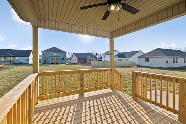 wooden deck featuring ceiling fan and a lawn