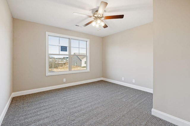 empty room with ceiling fan and dark carpet