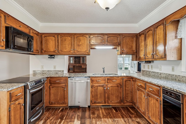 kitchen with sink, dark wood-type flooring, appliances with stainless steel finishes, light stone countertops, and ornamental molding