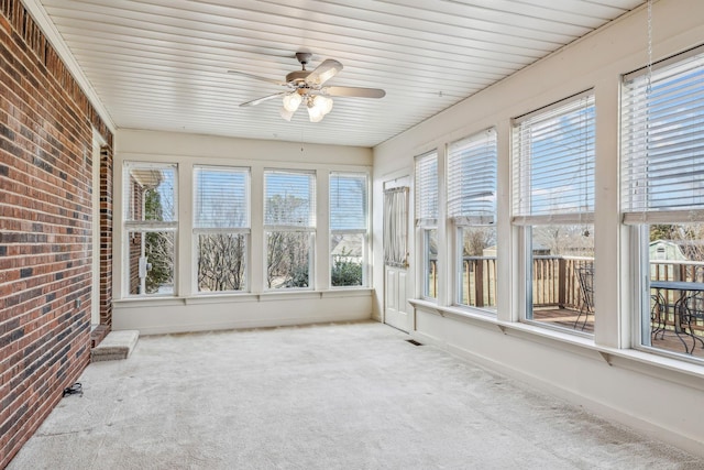 unfurnished sunroom featuring ceiling fan