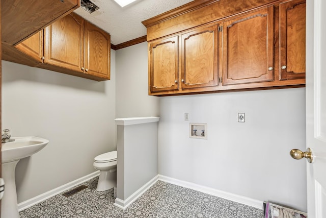 bathroom with toilet, sink, and a textured ceiling