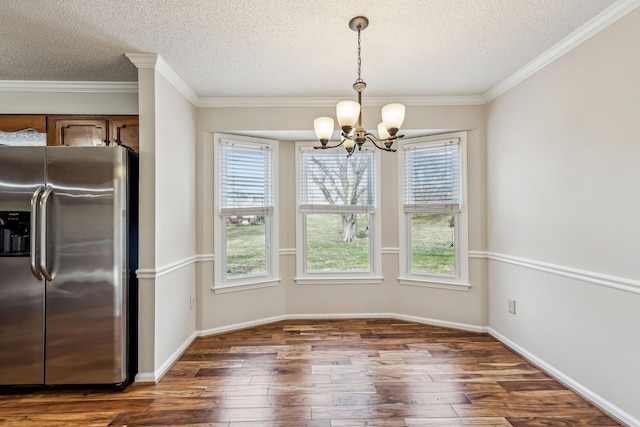 unfurnished dining area with dark hardwood / wood-style flooring, a notable chandelier, ornamental molding, and a textured ceiling