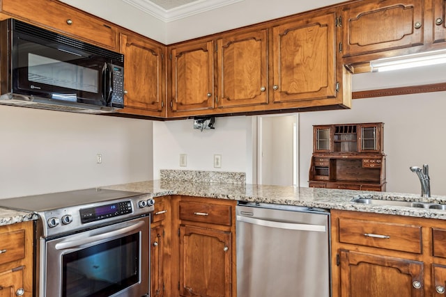 kitchen with sink, ornamental molding, stainless steel appliances, and light stone countertops