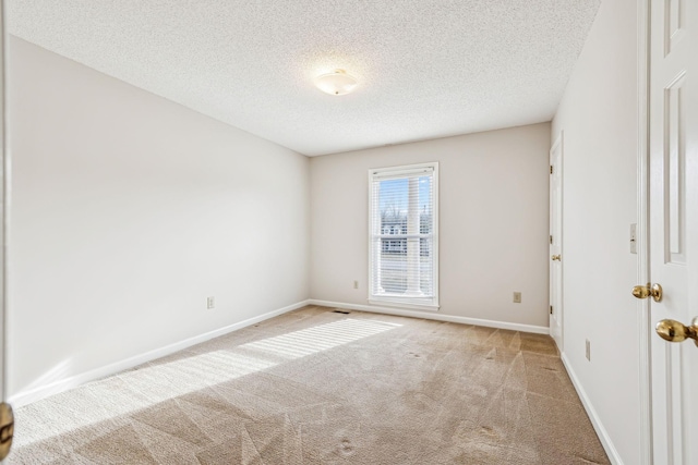 unfurnished room with light carpet and a textured ceiling