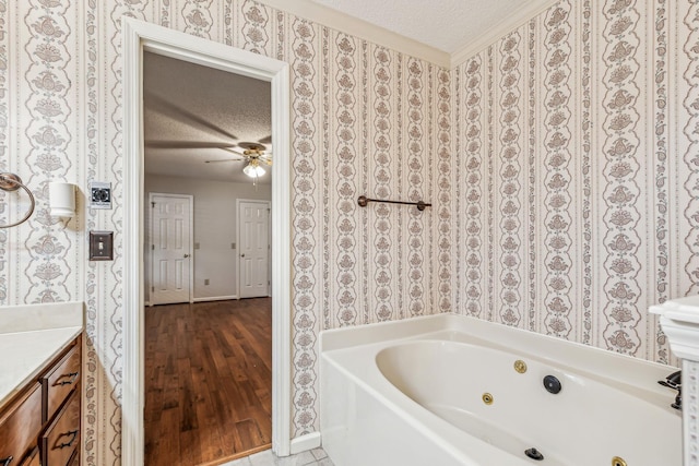 bathroom with tile patterned flooring, ceiling fan, a bathing tub, and a textured ceiling