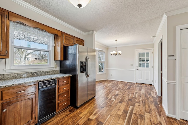 kitchen with hardwood / wood-style floors, decorative light fixtures, light stone counters, stainless steel refrigerator with ice dispenser, and an inviting chandelier