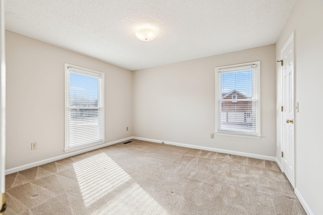 carpeted empty room featuring a textured ceiling