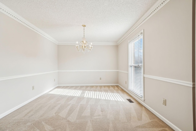 carpeted spare room with ornamental molding, a chandelier, and a textured ceiling