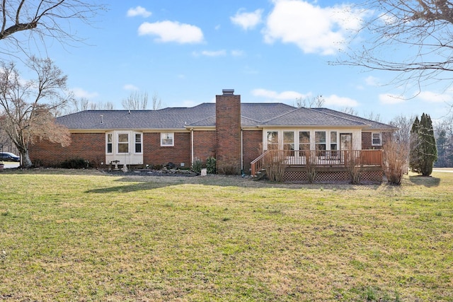 rear view of property with a wooden deck and a yard