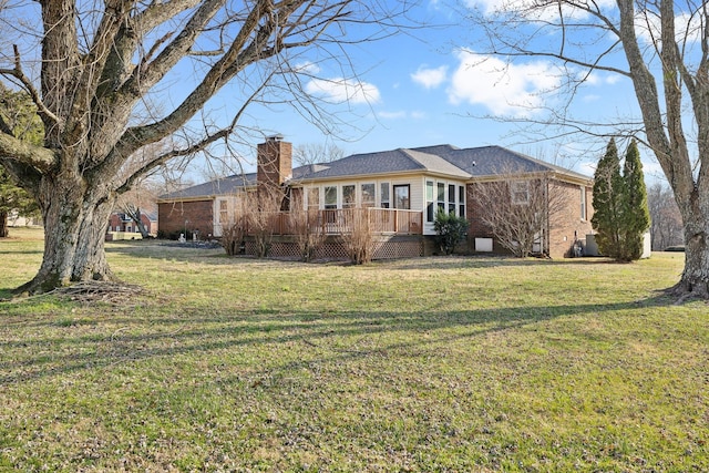 rear view of property with a yard and a deck