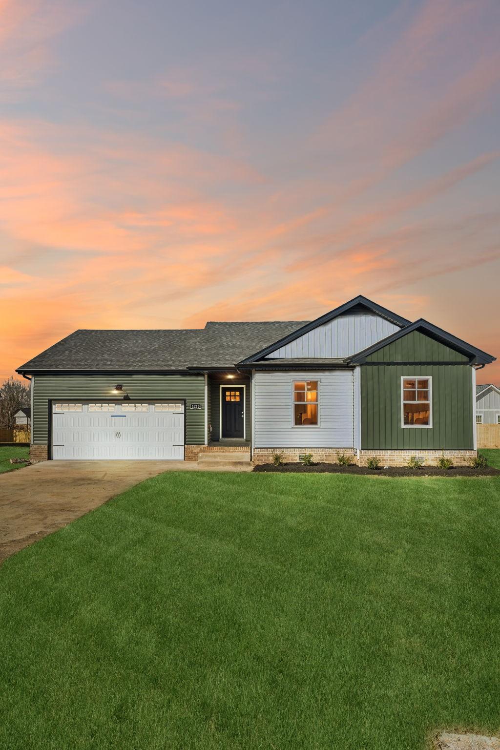 ranch-style house featuring a garage and a yard